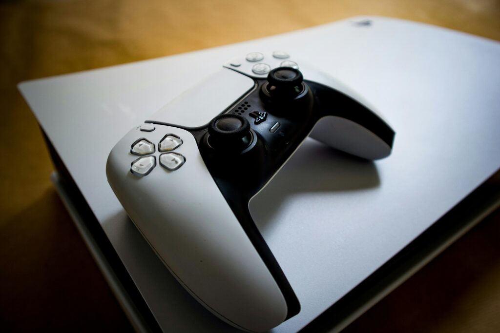 Detailed shot of a PlayStation 5 controller resting on the console, highlighting modern gaming design.